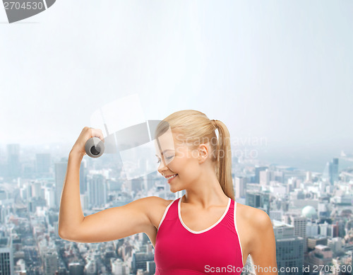 Image of young sporty woman with light dumbbell