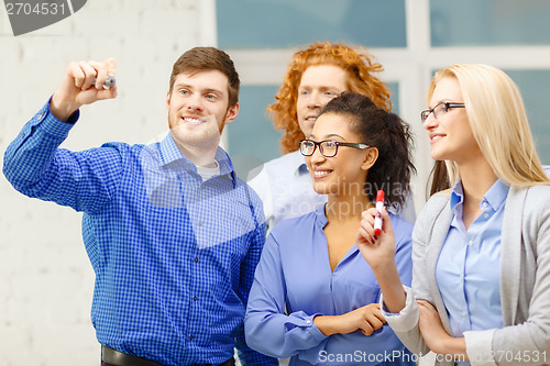 Image of smiling creative team writing on virtual screen