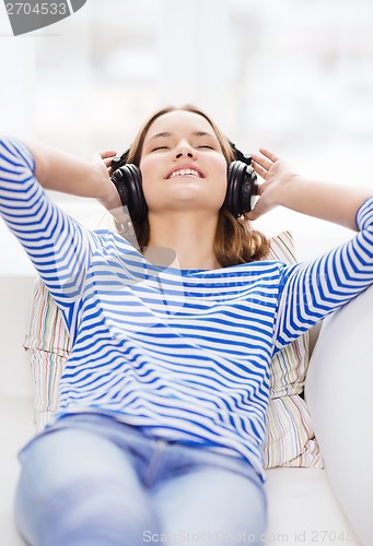 Image of smiling young girl in headphones at home