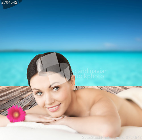 Image of smiling woman lying on the massage desk