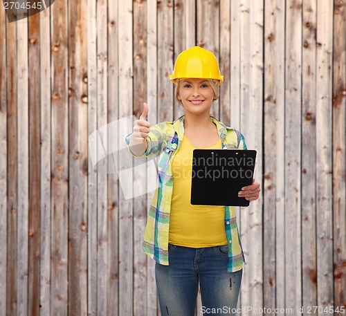 Image of smiling woman in helmet with clipboard