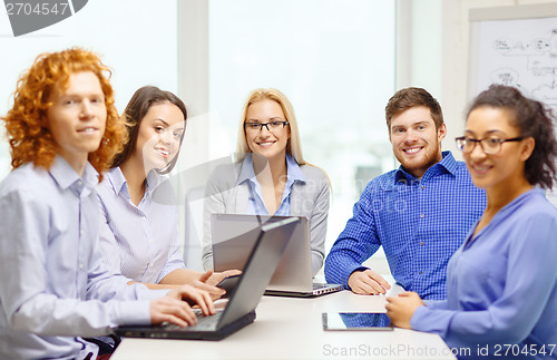 Image of smiling team with laptop and table pc computers