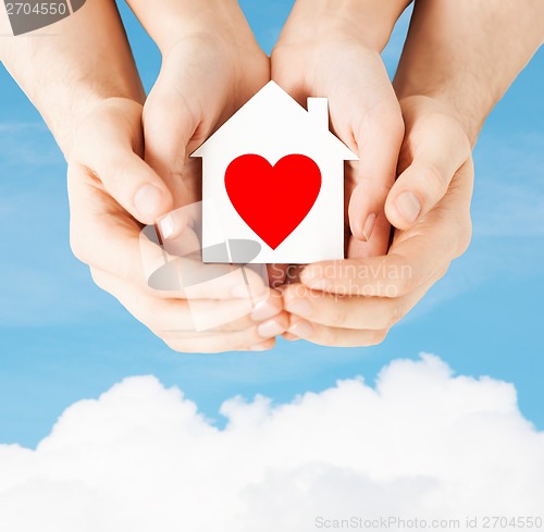 Image of couple hands holding white paper house