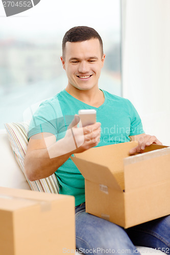 Image of opening cardboard box and taking out smartphone
