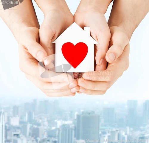 Image of couple hands holding white paper house