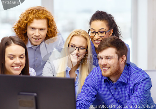 Image of smiling business team looking at computer monitor