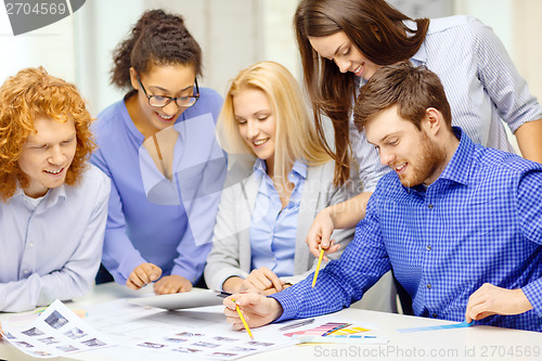 Image of smiling team with color samples at office