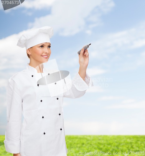 Image of smiling female chef writing something on air