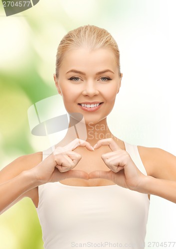 Image of smiling woman showing heart shape gesture