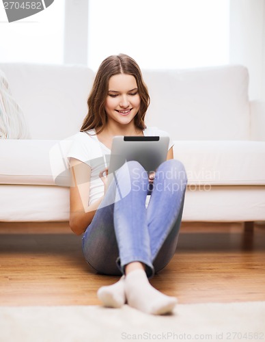 Image of smiling teenage girl with tablet pc at home