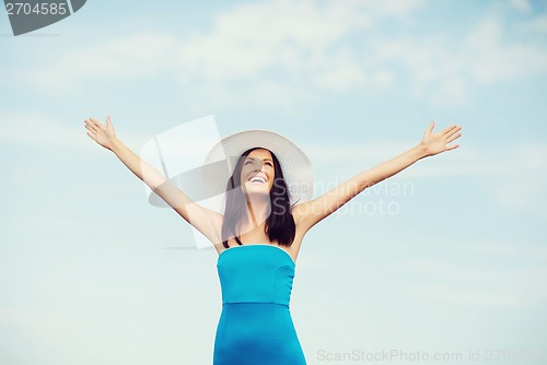 Image of girl with hands up on the beach