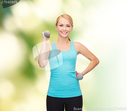 Image of young sporty woman with light dumbbells