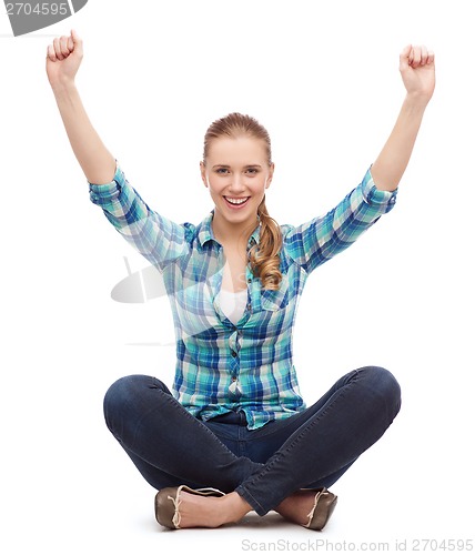 Image of young woman in casual clothes sitting on floor