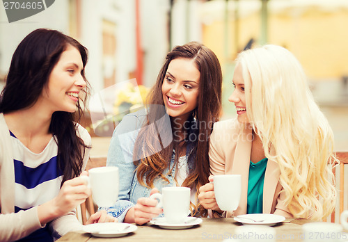 Image of beautiful girls drinking coffee in cafe