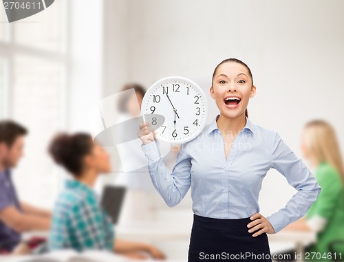 Image of attractive teacher with wall clock