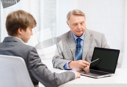 Image of older man and young man with laptop computer