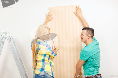 Image of smiling couple choosing wallpaper for new home