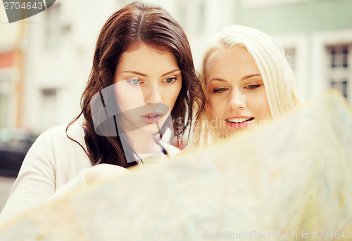 Image of beautiful girls looking into tourist map in city