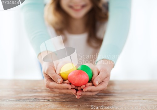 Image of close up of girl and mother holding colored eggs