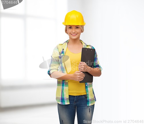 Image of smiling woman in helmet with clipboard
