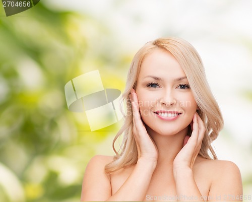 Image of woman touching her face skin