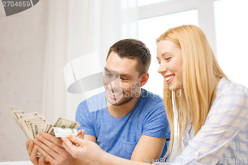 Image of couple with money at home