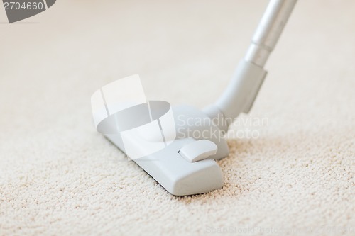 Image of close up of male hoovering carpet