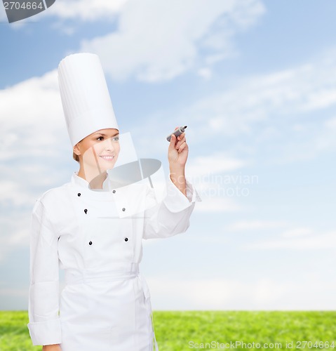 Image of smiling female chef writing something on air