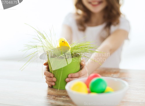Image of close up of girl holding pot with green grass