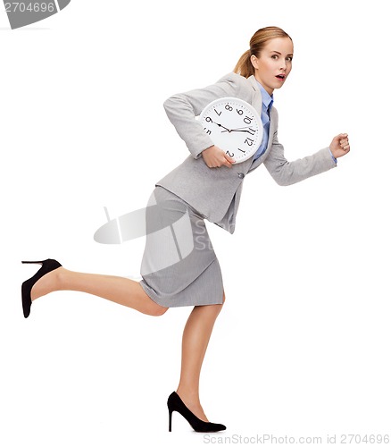 Image of stressed young businesswoman with clock running
