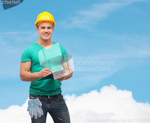 Image of smiling man in helmet with clipboard