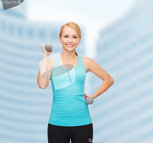 Image of young sporty woman with light dumbbells