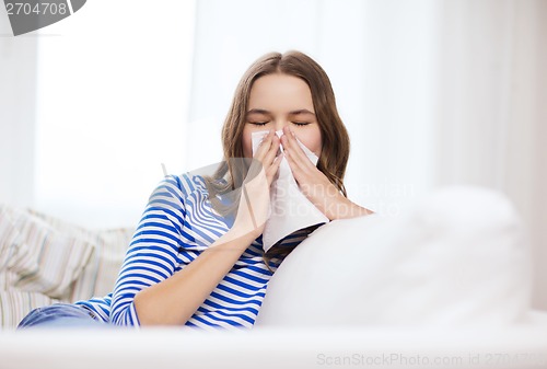 Image of sick teenage girl with paper tissue