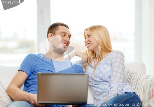 Image of smiling happy couple with laptop at home