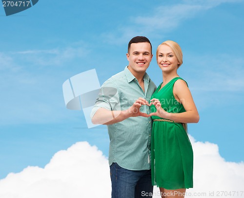 Image of smiling couple showing heart with hands