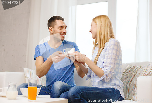 Image of man giving his girlfriend or wife cup of coffee