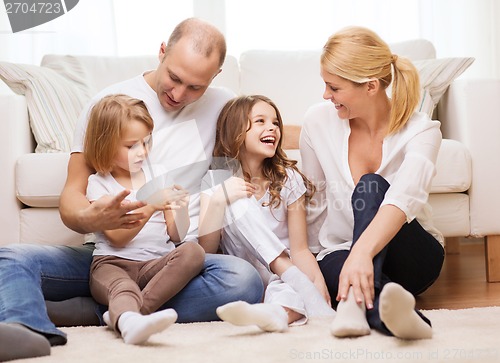 Image of parents and two girls sitting on floor at home