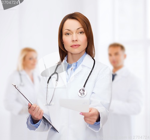 Image of calm female doctor with clipboard