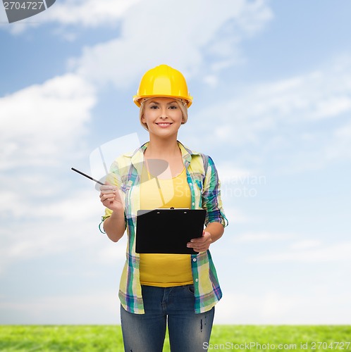 Image of smiling woman in helmet with clipboard