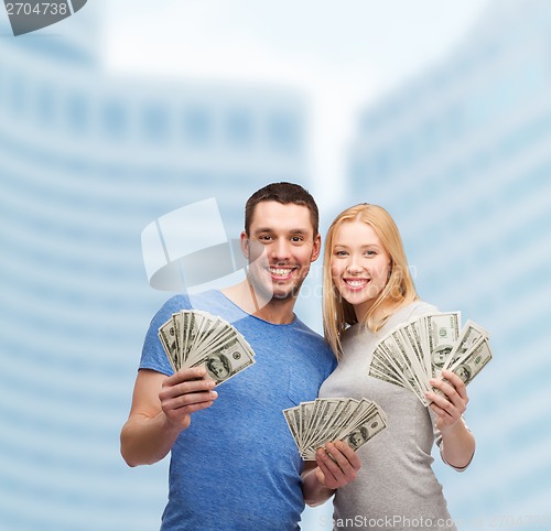 Image of smiling couple holding dollar cash money