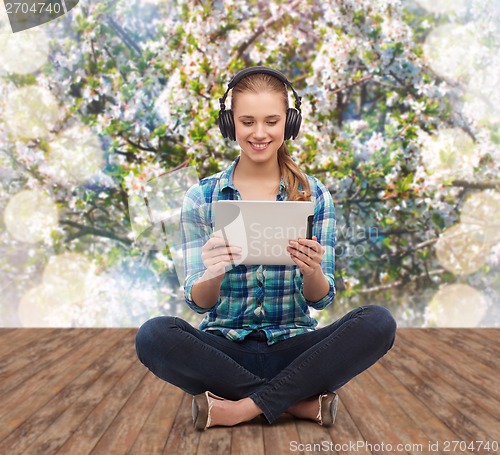 Image of young woman in casual clothes sitting on floor