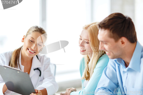 Image of smiling doctor with patients in hospital