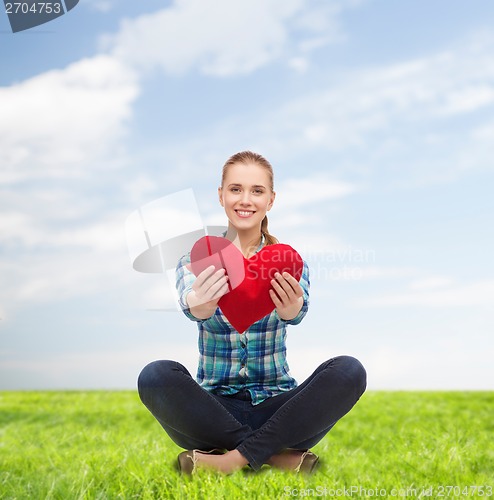 Image of young woman in casual clothes sitting on floor