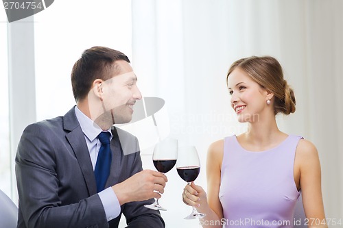 Image of young couple with glasses of wine at restaurant