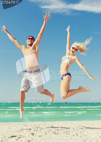 Image of couple jumping on the beach