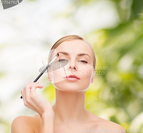 Image of beautiful woman with makeup brush