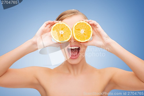 Image of amazed young woman with orange slices