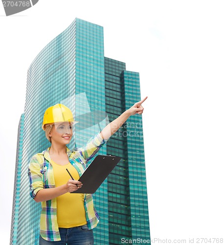 Image of smiling woman in helmet with clipboard