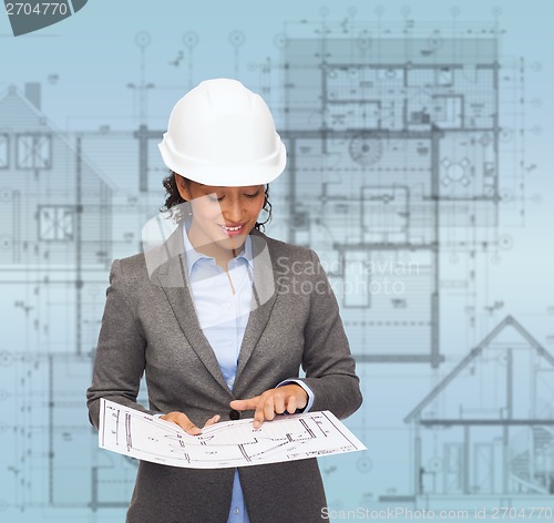 Image of businesswoman in white helmet with blueprint