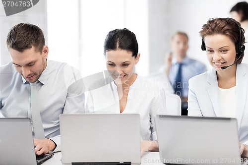 Image of group of people working with laptops in office